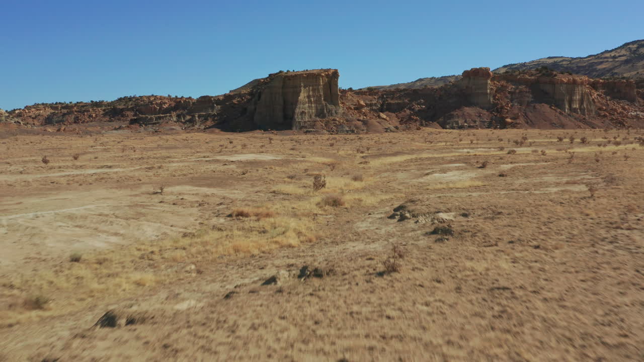 antena del desierto pasando por encima del coche en camino de tierra para revelar formaciones rocosas