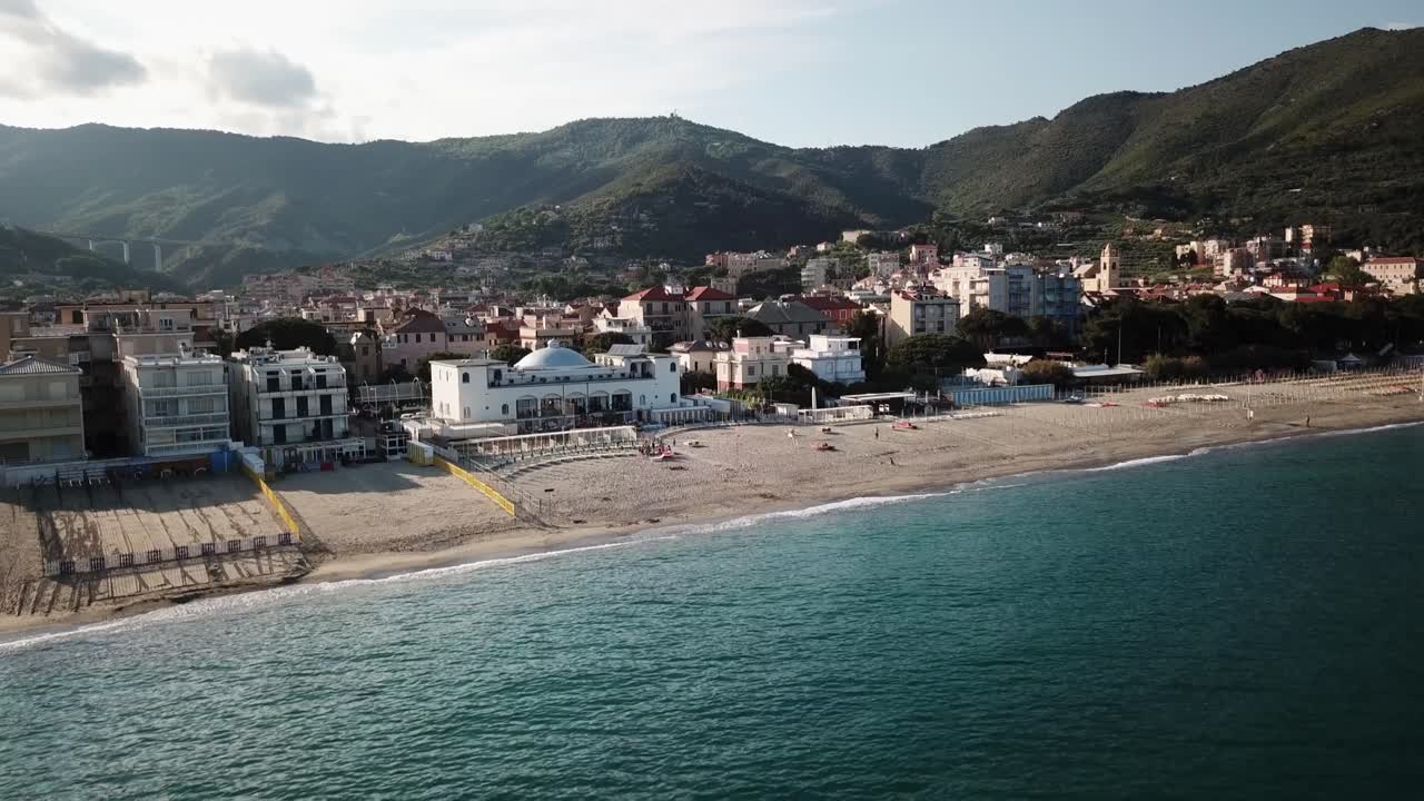 vista de drones del mediterráneo con una playa de arena, un pueblo y montañas