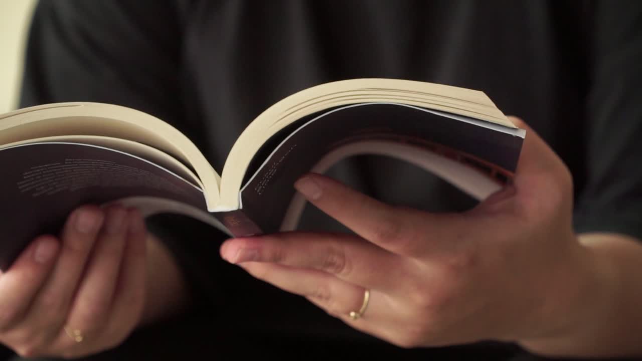 Close-up shot of a person hold open book highlighting calm moments of reading and concentration