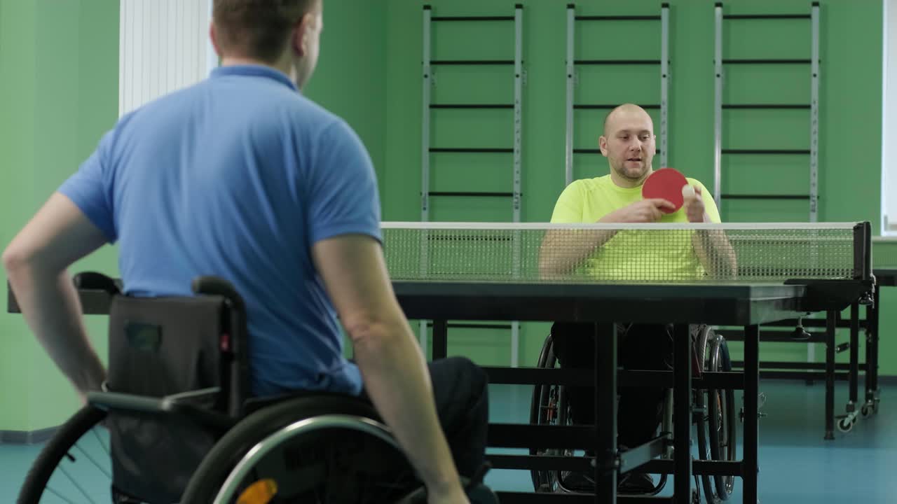 un hombre en silla de ruedas juega al ping-pong. personas con discapacidad juegan al tenis de mesa. rehabilitación de discapacitados. deporte.