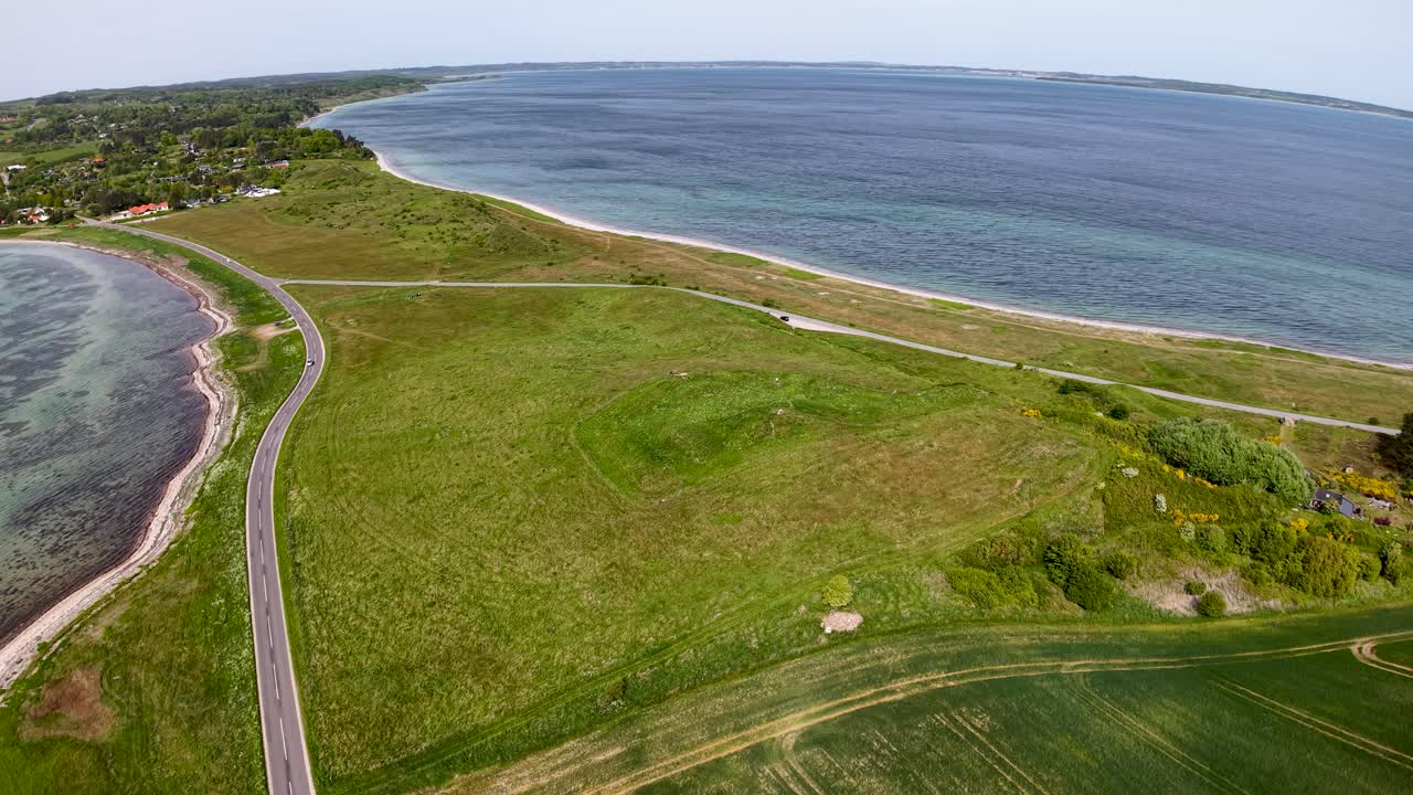 Aerial view of Dragsmur’s narrow land bridge between sea inlets, with winding roads and grassy terrain