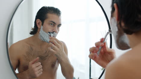 hombre afeitándose en el baño
