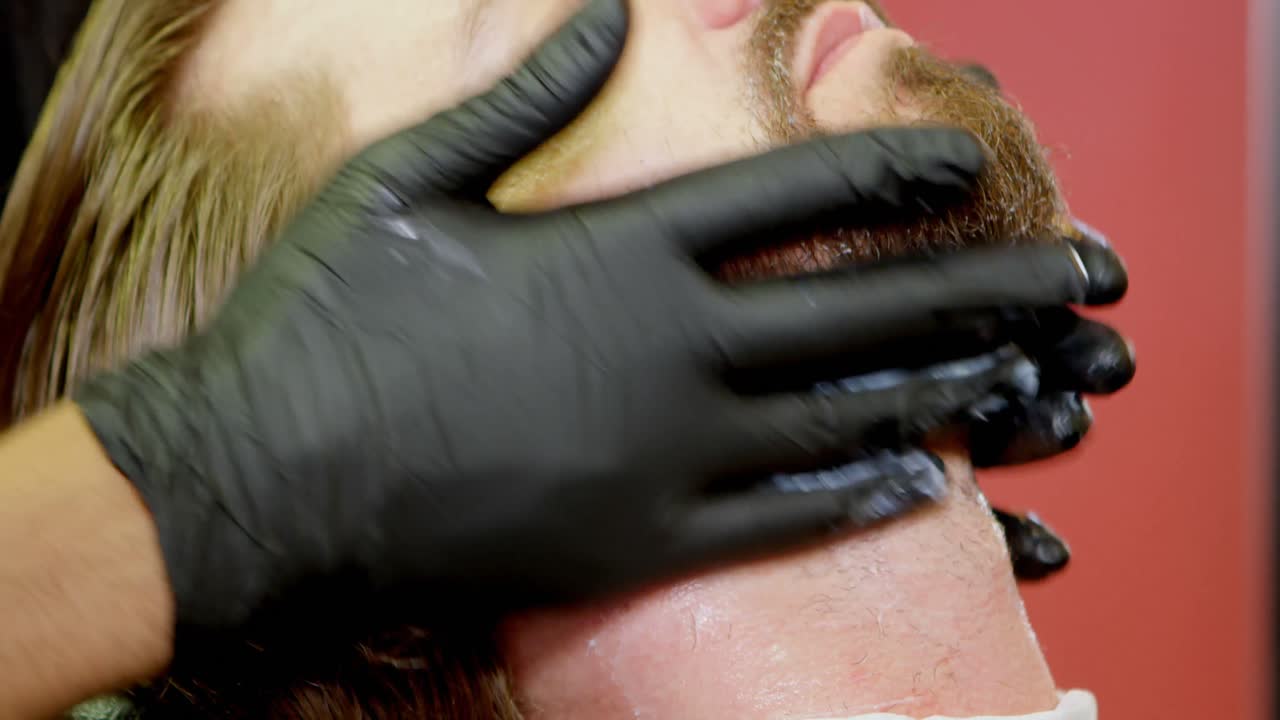 헤어 살롱 4k에서 얼굴 마사지를 받는 남자