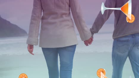 Animation-of-cocktail-glasses-falling-over-caucasian-couple-in-love-holding-hands-by-seaside