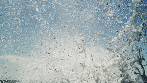 super slow-motion water column bursts skyward from ocean surface in powerfully lit scene