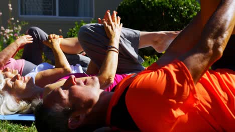 side view of caucasian male trainer training senior people in performing exercise at the garden of n