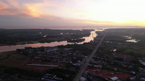 Vista-Aérea-Al-Atardecer-De-Surat-Thani-Es-Una-Ciudad-En-Amphoe-Mueang-Con-Río-Y-Ferry-Para-Ir-De-Isla-En-Isla,-Destino-Turístico-De-Vacaciones-En-Tailandia,-El-Sudeste-Asiático