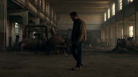 man walking through an abandoned industrial building