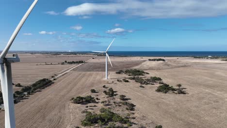 tracking drone shot of spinning wind turbine