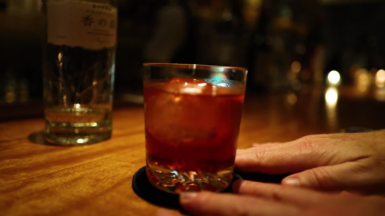 dos manos intercambiando un cóctel en una montaña rusa