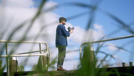 man taking picture outdoors with an analog camera in amsterdam - wide