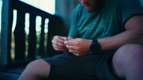 man putting bait on hook for fishing - close up