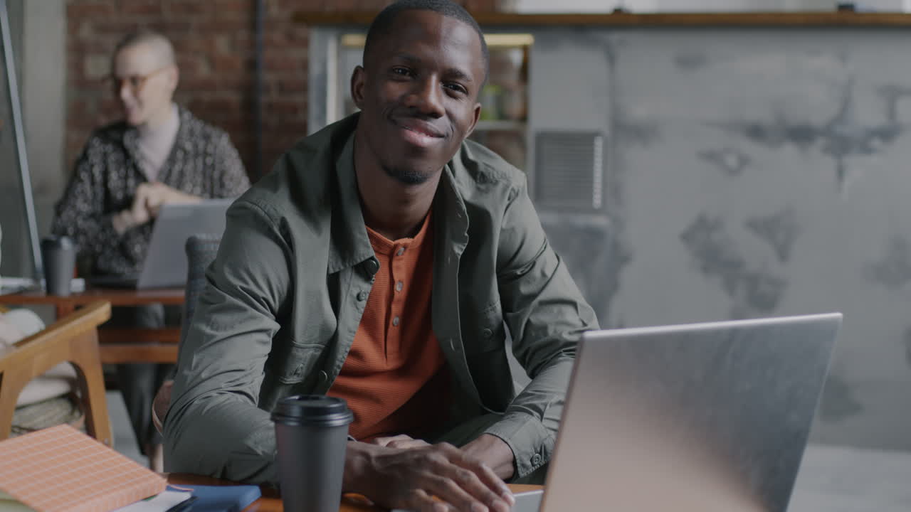 Man Working on Laptop in a Cafe