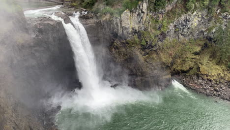 agua cayendo sobre las cataratas snoqualmie en el estado de washington, con niebla a su alrededor