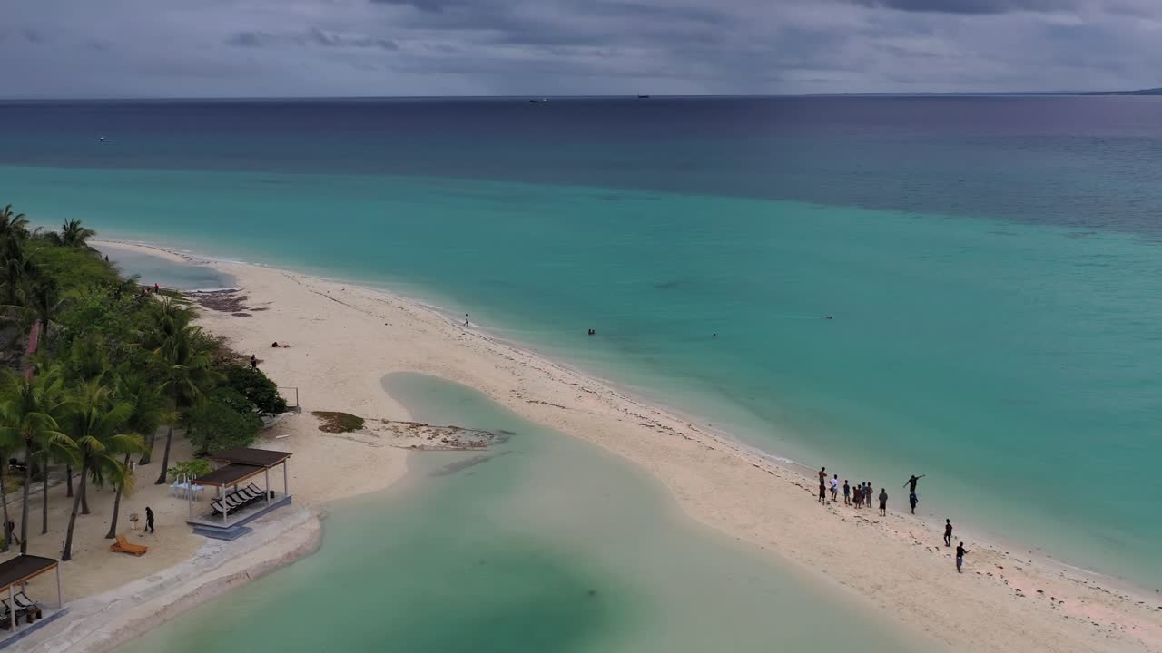 Kota beach in Bantayan Island Philippines with people enjoying a shallow swim, Aerial flyover shot
