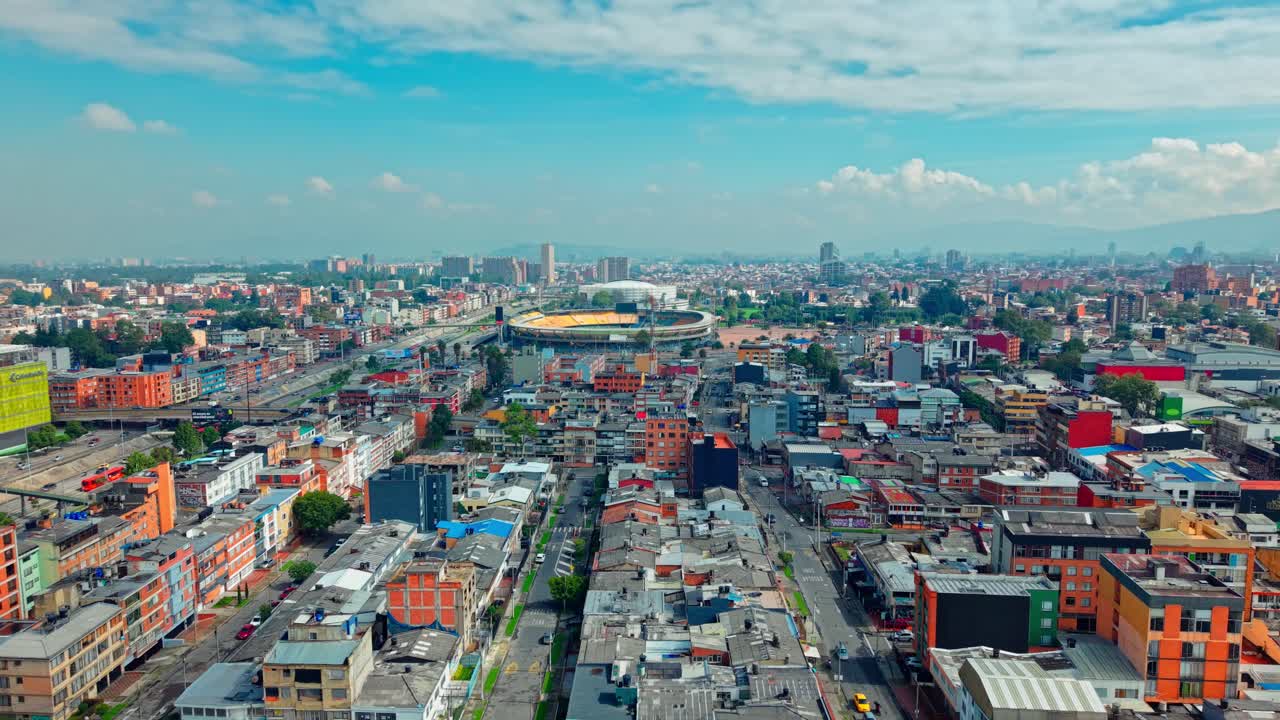 Aerial view rising in Teusaquillo right over the low-rise buildings near the El Campin soccer stadium on a sunny day, Bogota, Colombia