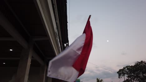 indonesian flag red and white waves windy under full moon skyline, closeup view