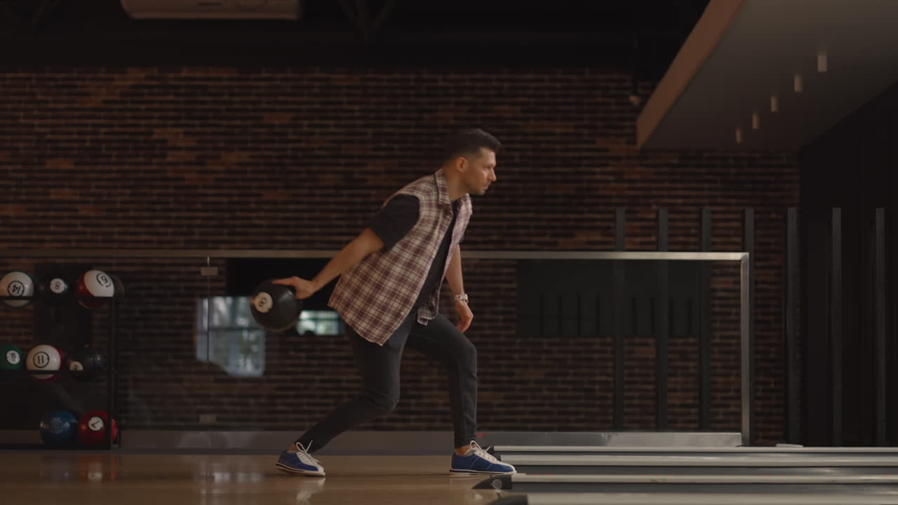 Un uomo caucasico lancia una palla da bowling e fa strike, balla, salta e canta esultando per la vittoria