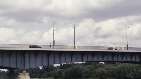 a pedestrian on a bridge and slow-moving cars