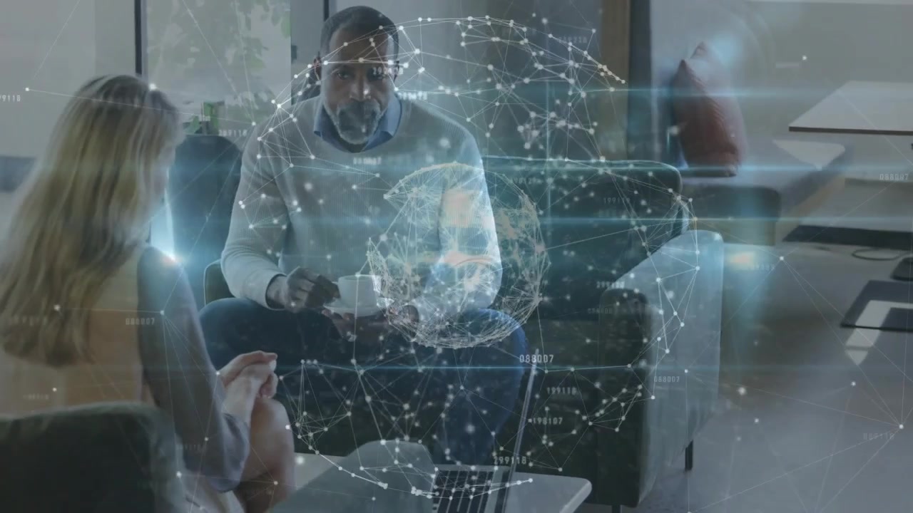 Man tapping device and projecting AR globe while woman pointing at laptop, reviewing business data