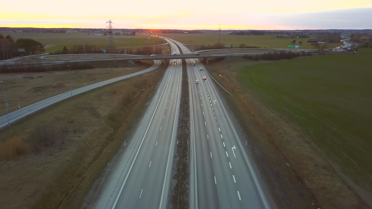 Vista aerea di uno svincolo autostradale con traffico veicolare in movimento.