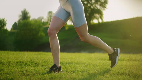 a woman performs squats on one leg with a backward lunge and a high hip lift. training in the park in summer for legs and thighs at sunset