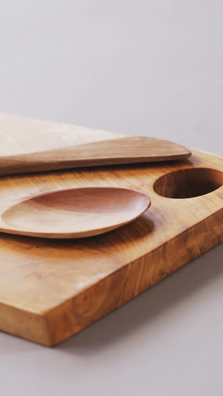 Cucchiaio e spatola di legno su tagliere di legno