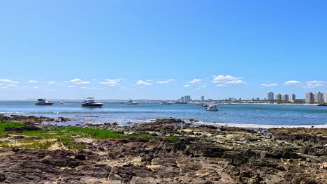 Skyline-of-Punta-del-Este,-with-yachts,-beach-and-waves-in-front,-Uruguay,-Summer