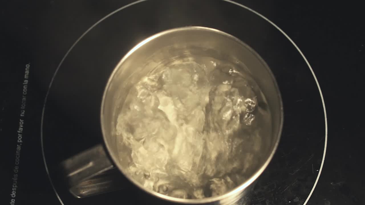 Metal pot of boiling water in slow motion