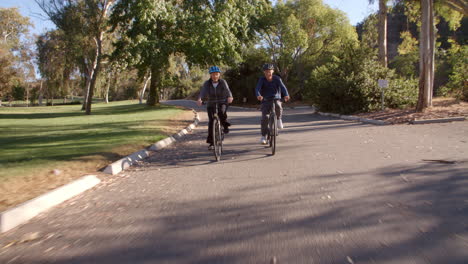 Pareja-Mayor-En-Bicicleta-Por-El-Parque-En-Cámara-Lenta