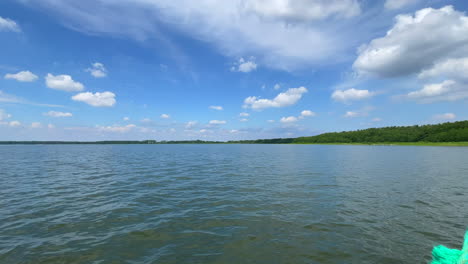 a boat sails across a lake in beautiful weather in slow motion