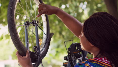 woman repairing bicycle with wrench