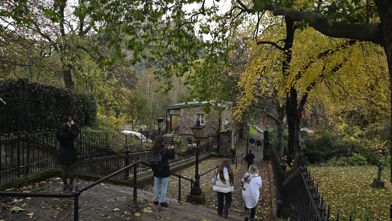Tourists walk and take photos at Princes Street Gardens steps, Edinburgh