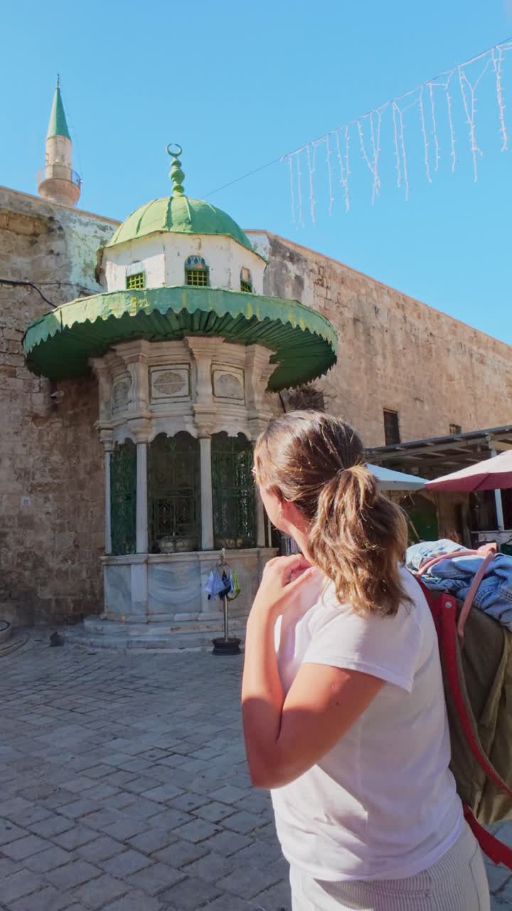 Turista donna che ammira l'architettura antica e un minareto nella Città Vecchia