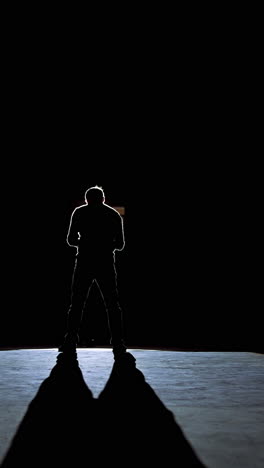 senior man in costume on stage in darkness. active man in hat dancing on stage during the performance in the theater. vertical video