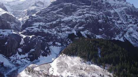 Imágenes-Aéreas-Sobrevolando-Un-Paisaje-Glacial-Nevado-Sobre-Un-Río-En-Dirección-A-Grandes-Acantilados-De-Piedra-Caliza