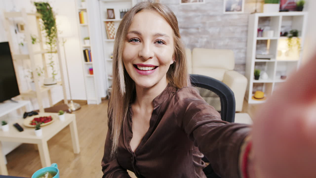 Selfie of a blond woman in a living room