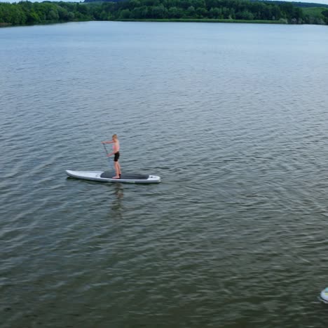 two persons on paddle board. drone view of couple on sup paddle boards