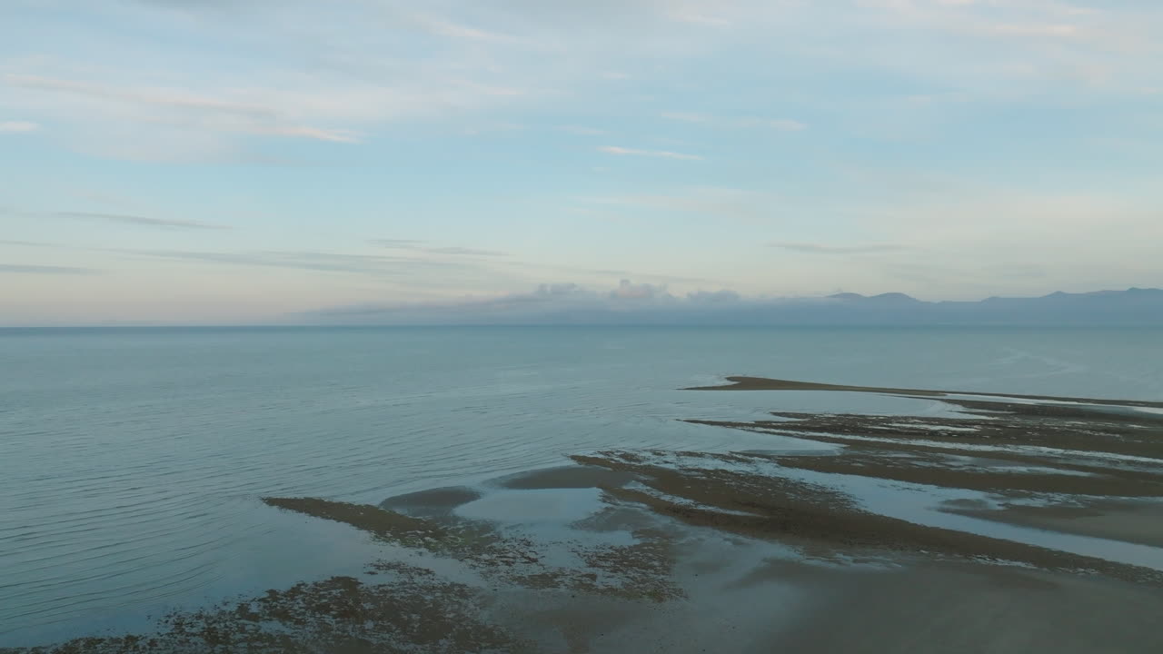 해안선을 지나 멀리 있는 산을 향해 날아다니는 드론, 타스만 지역, 뉴질랜드