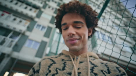 man hands typing smartphone screen on evening street closeup. smiling latin guy