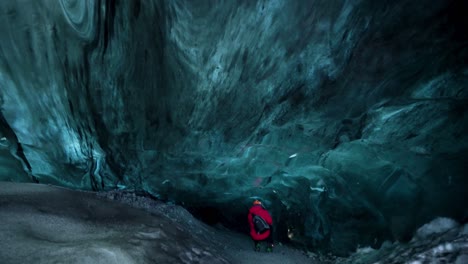 adventurous traveler exploring inside freezing cold ice cave