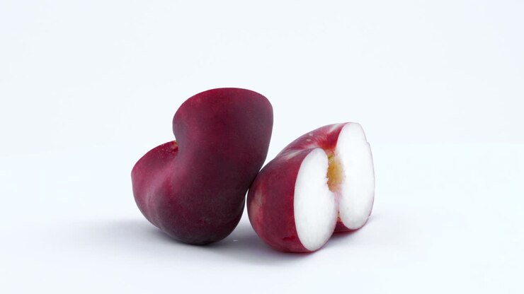 Two halves of a doughnut flat peach with the pit rotating on the turntable. Isolated on the white background. Close up.