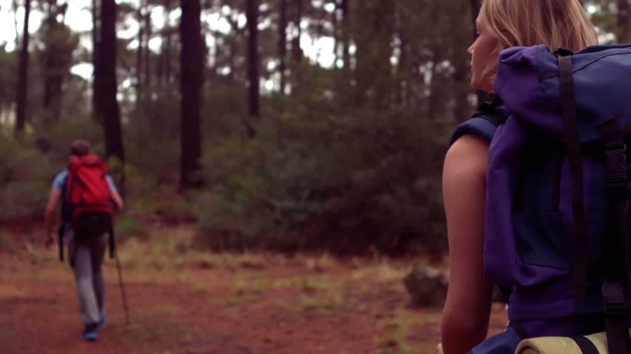 una pareja caminando por un bosque.