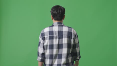 back view of asian man walking and looking around in green screen background