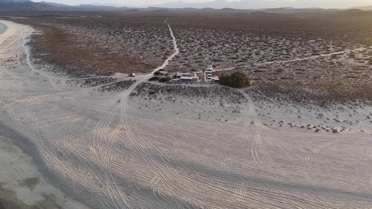Aerial view of a striped lighthouse on the beach in Punta Arena, Baja California Sur, Mexico.