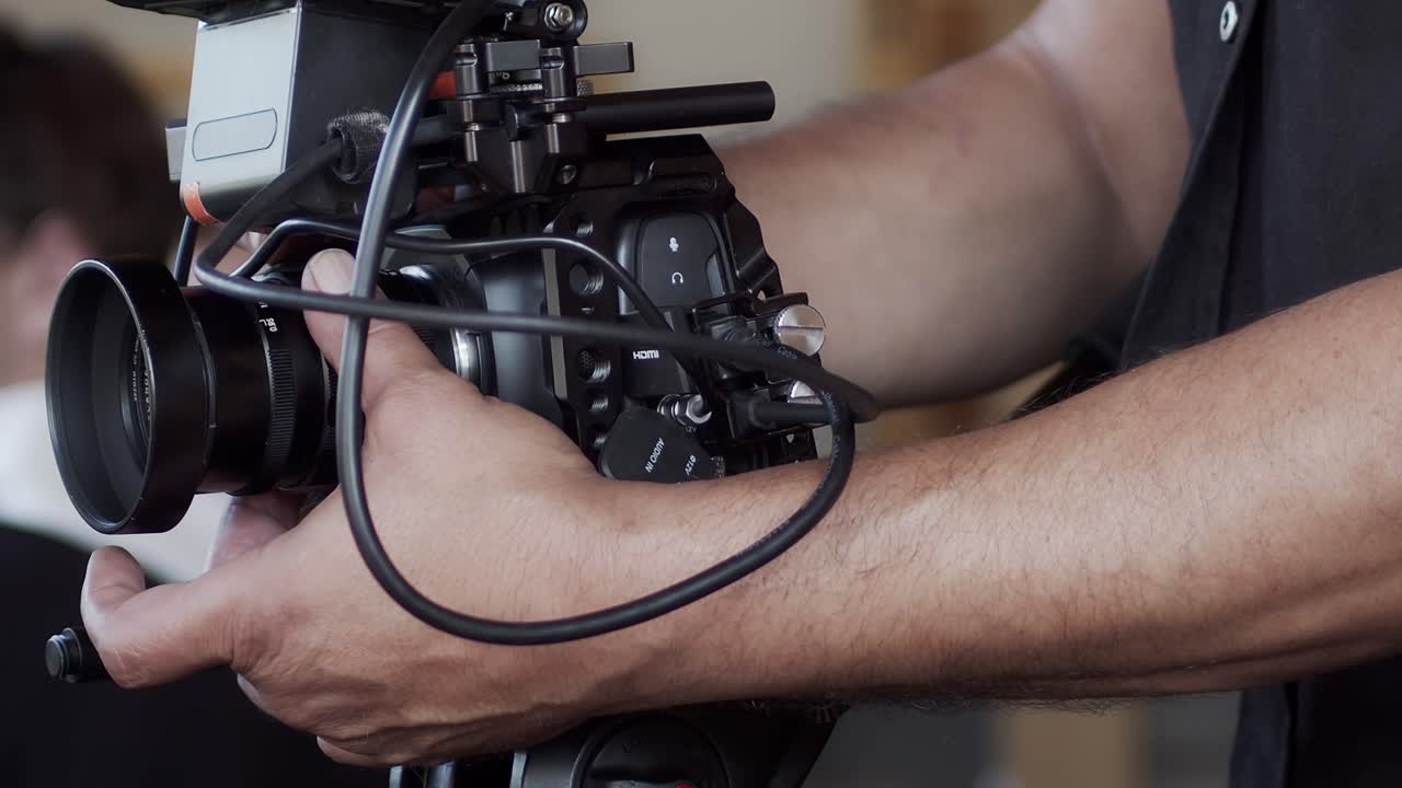 el camarógrafo ajusta la apertura y se enfoca en la cámara para la siguiente toma