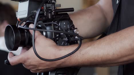 el camarógrafo ajusta la apertura y se enfoca en la cámara para la siguiente toma