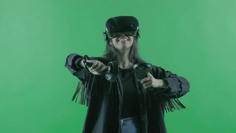 young woman playing in the vr headset. virtual reality helmet on the green background. chroma key