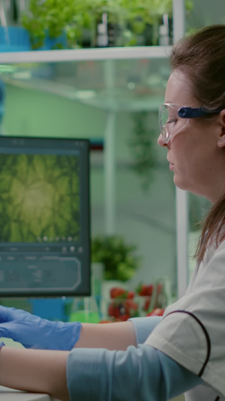 Scientist in laboratory conducting plant research and measuring growth