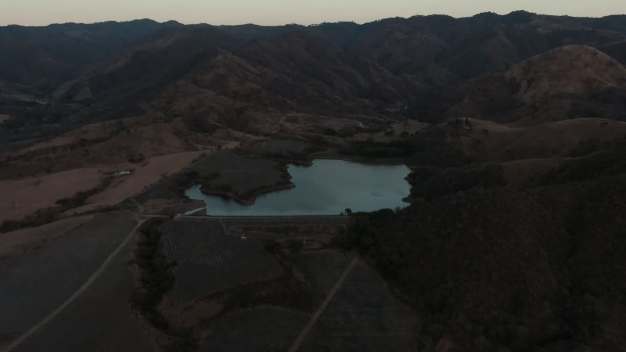 Presa de Huizilacates reservoir nestled among dry rolling hills and layered mountain ridges near Tecalitlán, Jalisco, Mexico
